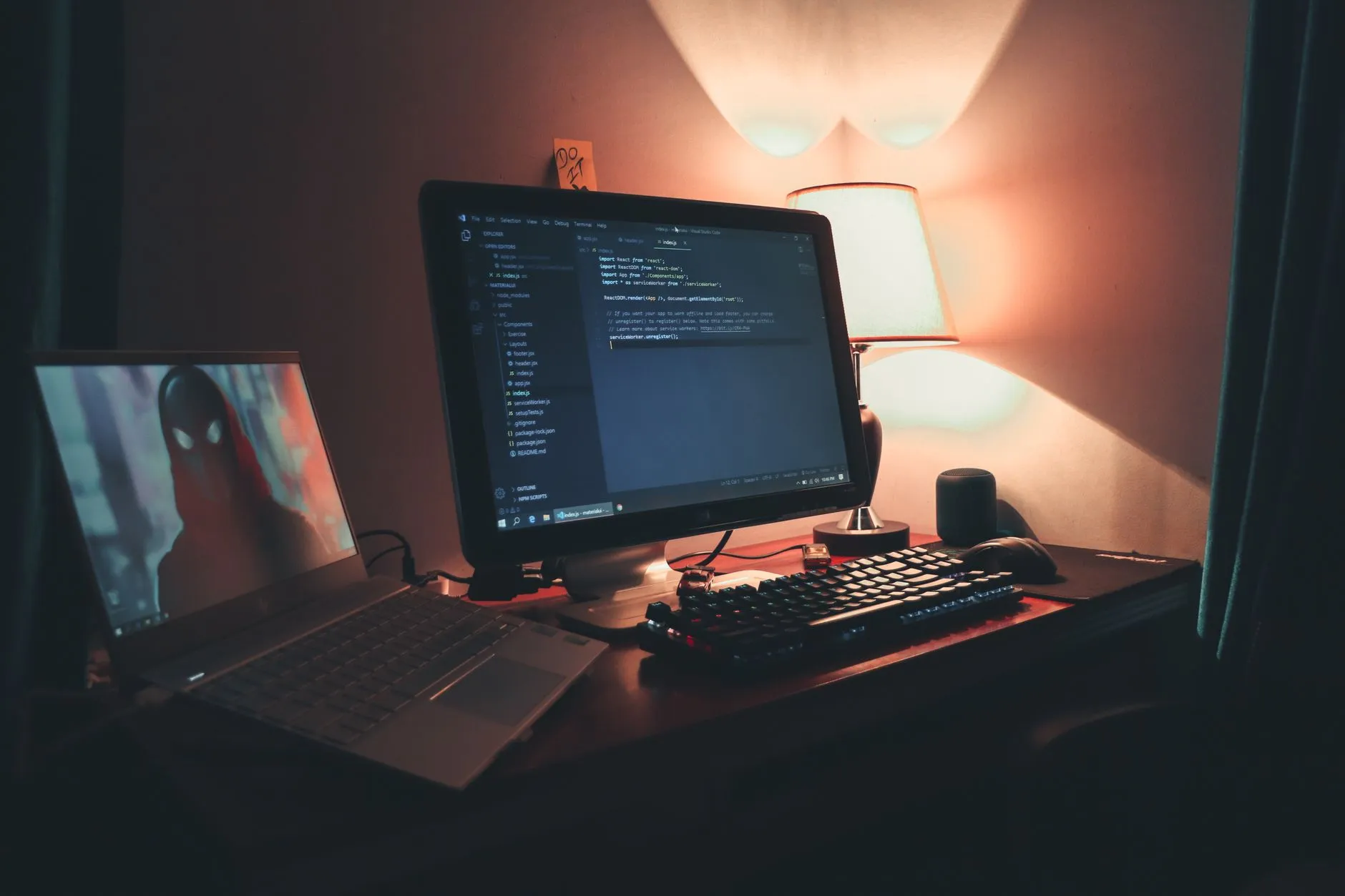 a dim desk with code on dual monitors
